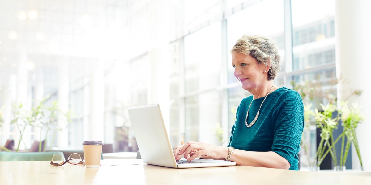 person working on laptop in office wearing turquoise top