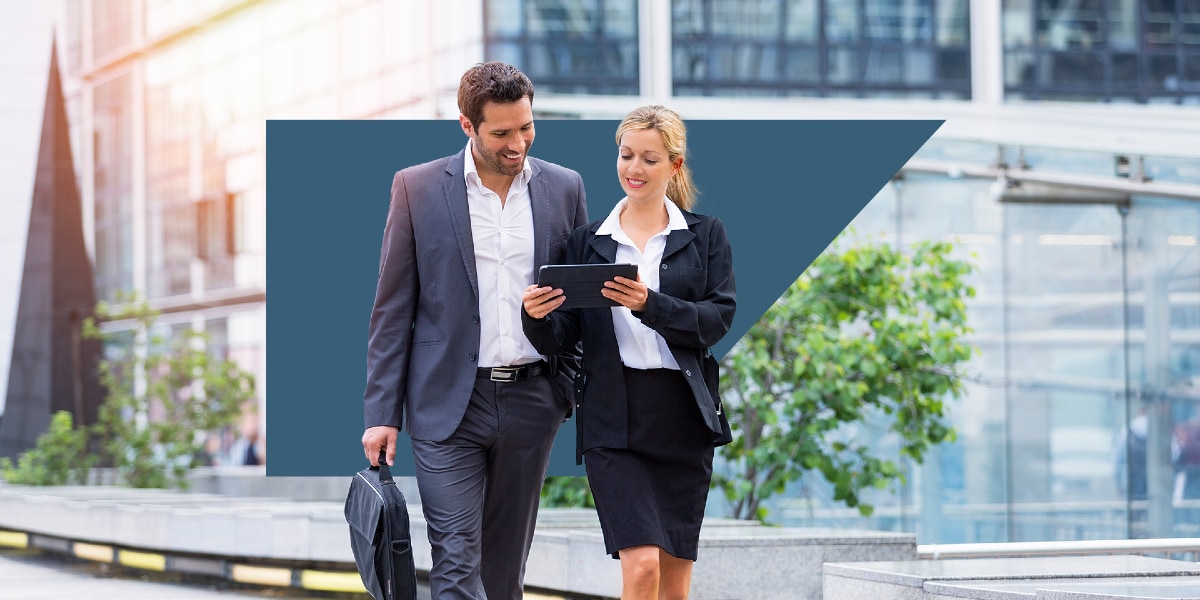 two people walking together looking at tablet